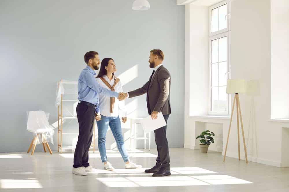 couple shaking hands with estate agent